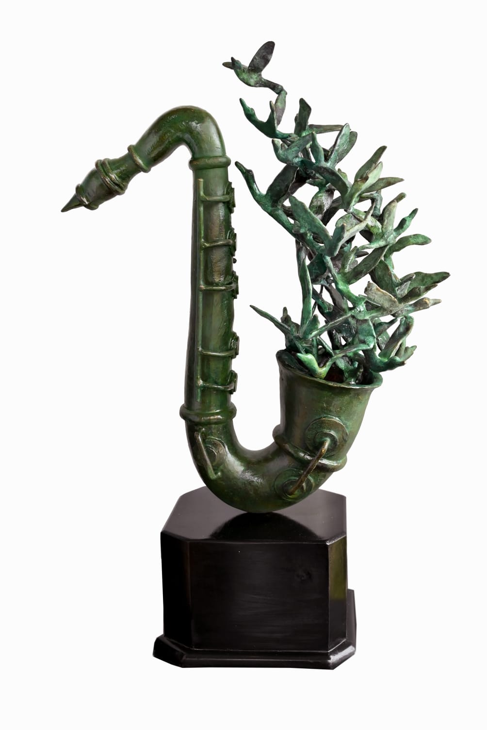 A green patinated brass sculpture of a saxophone by BIplab Sarkar, with flock of birds emerging from it, set on a hexagonal wooden base.