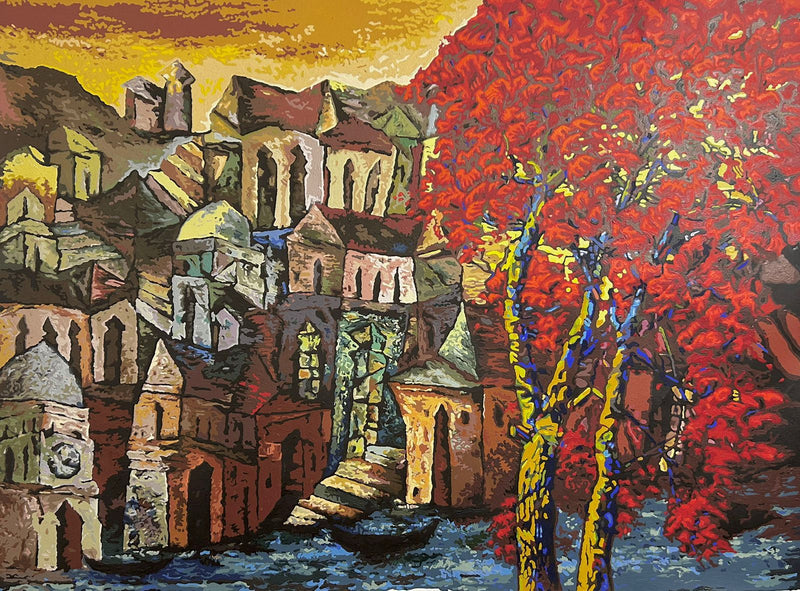 Dusk sets  on a seaside town as a red tree blossoms in forefront. 