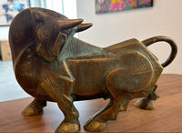 A bronze bull figurine by Dinkar Jadhav with geometric, stylized details. 