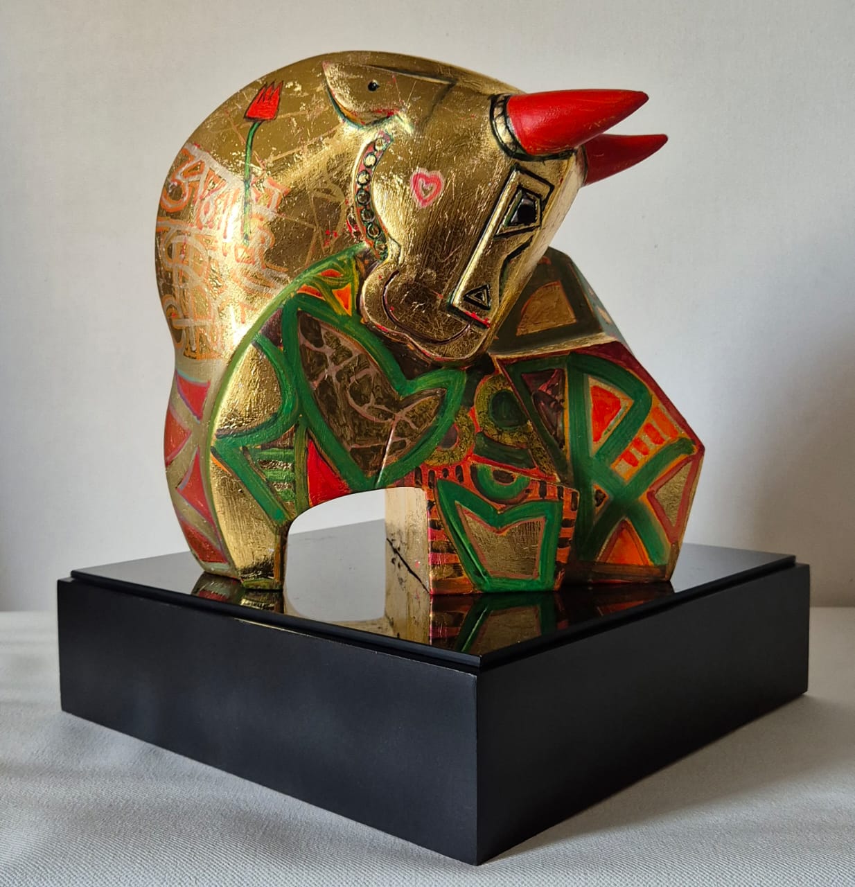 Dinkar Jadhav's gold toned fiberglass bull sculpture bust with red horns and body painted in Cubist style.