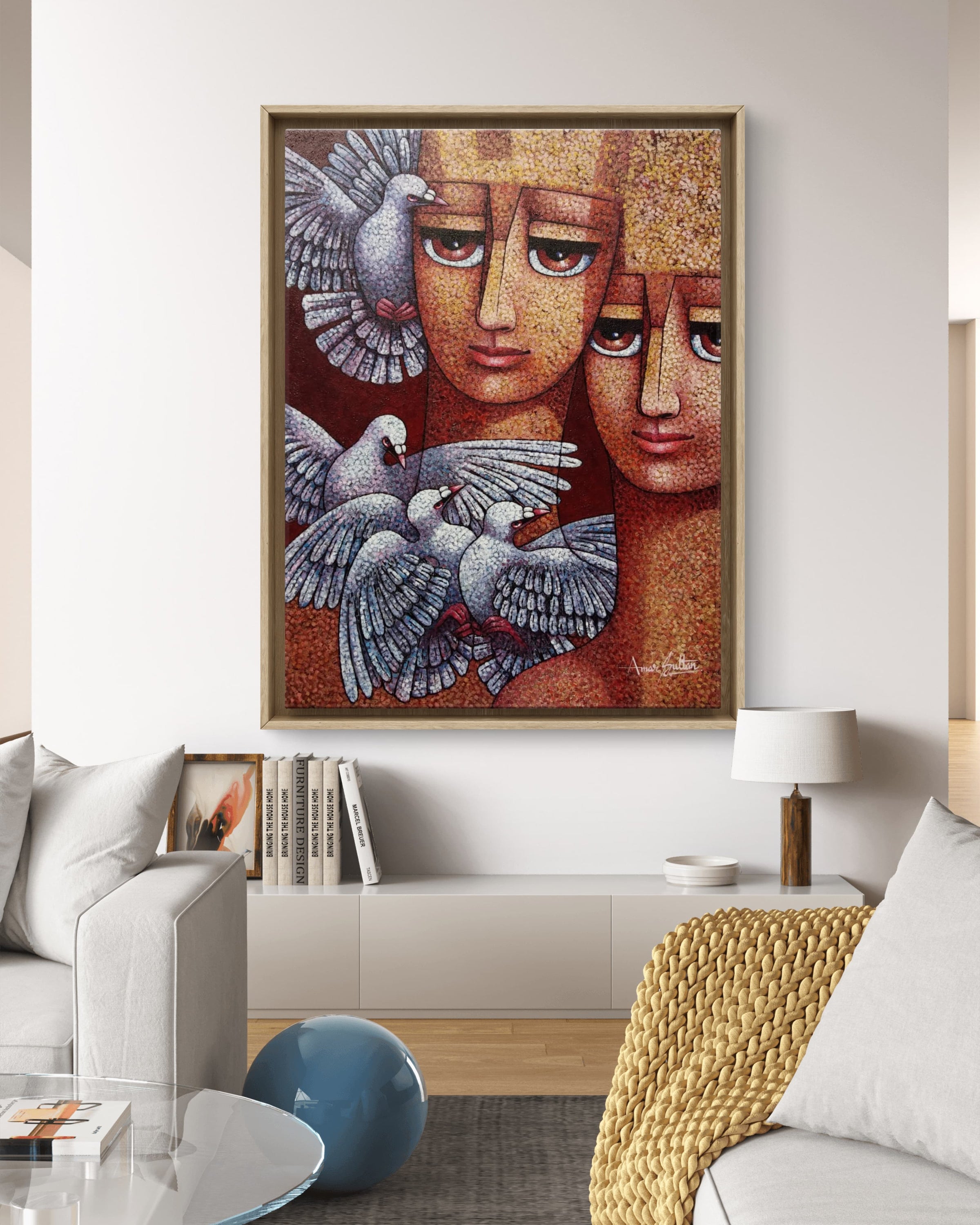 Framed artwork with two faces and doves in a living room setting. 