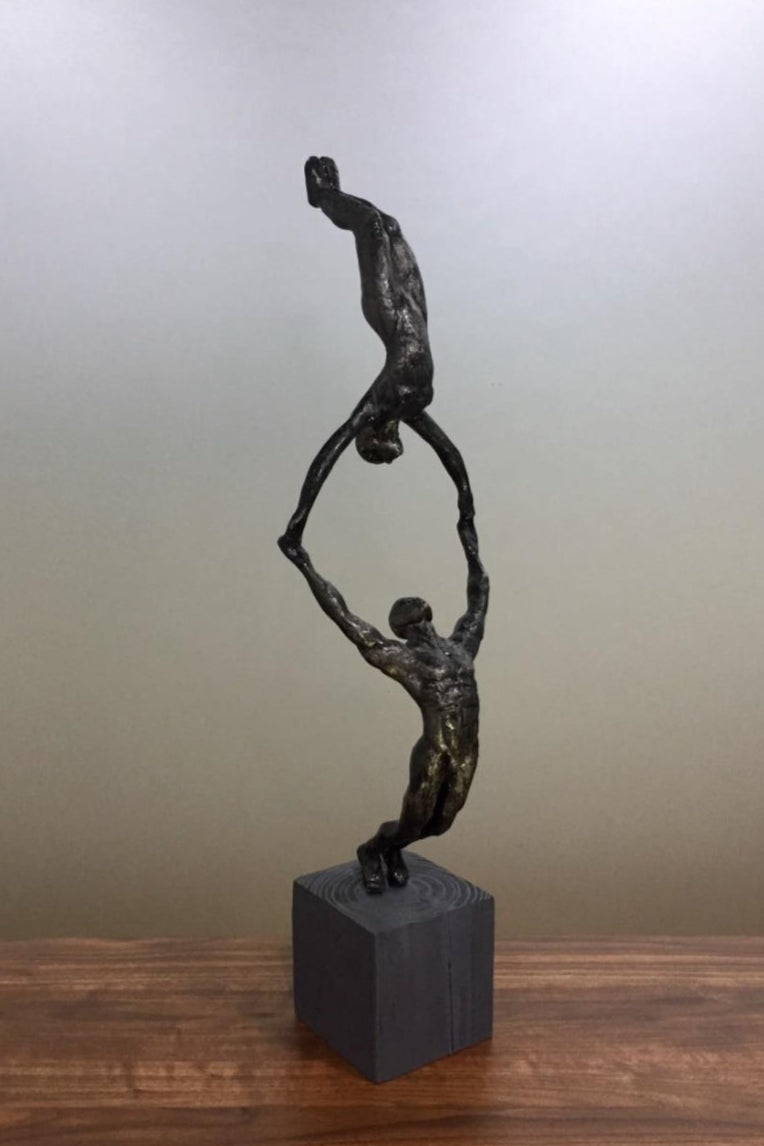 Aluminium sculptures depicting agility and strength of two gymnasts in action as they display balance.