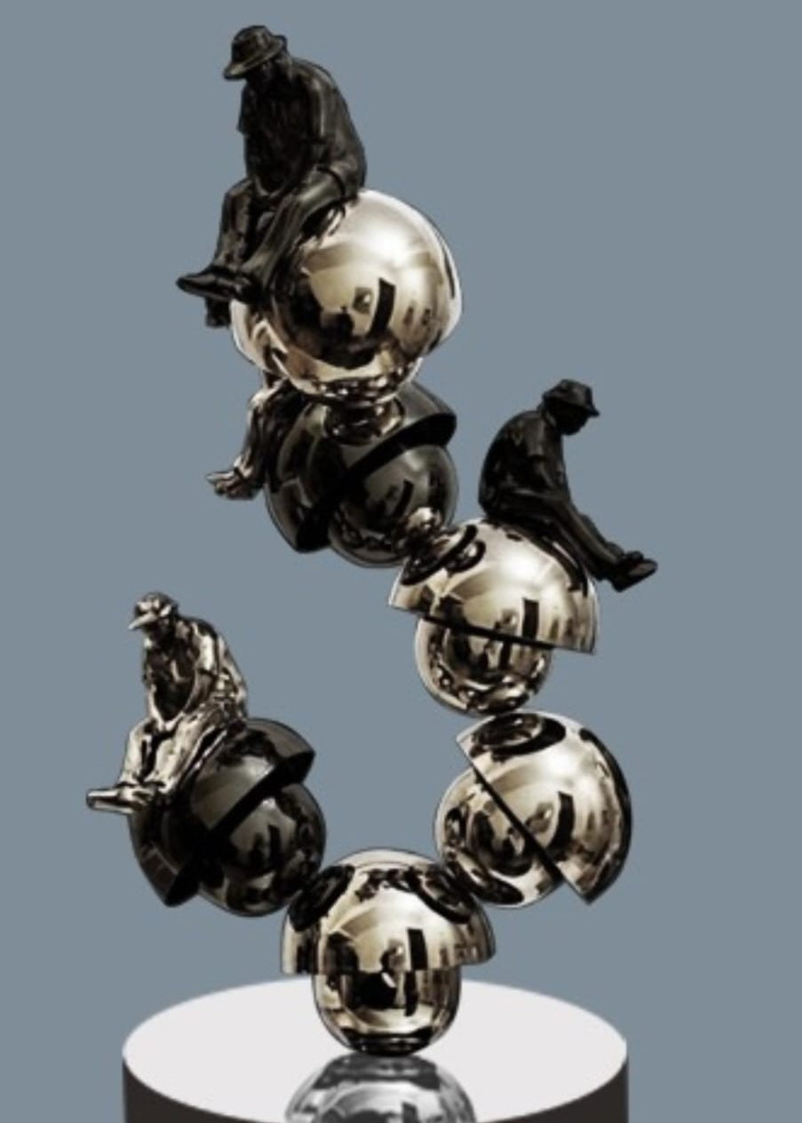 Shovin Bhattacharjee limited edition sculpture - a metallic and matte black tower sculpture featuring fused spheres with seated figures atop spheres.