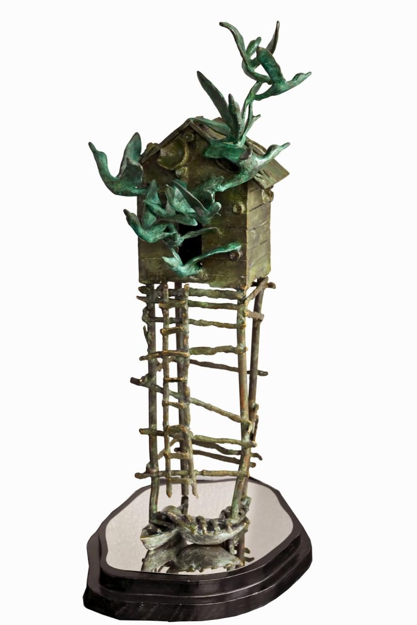 Home to Dreams waterside hut bronze sculpture by Biplab Sarkar with birds flying out and docked boats.
