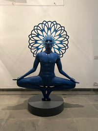 Front View of the 6ft Vernika Singh  sculpture; man in yoga posture with halo behind him. 