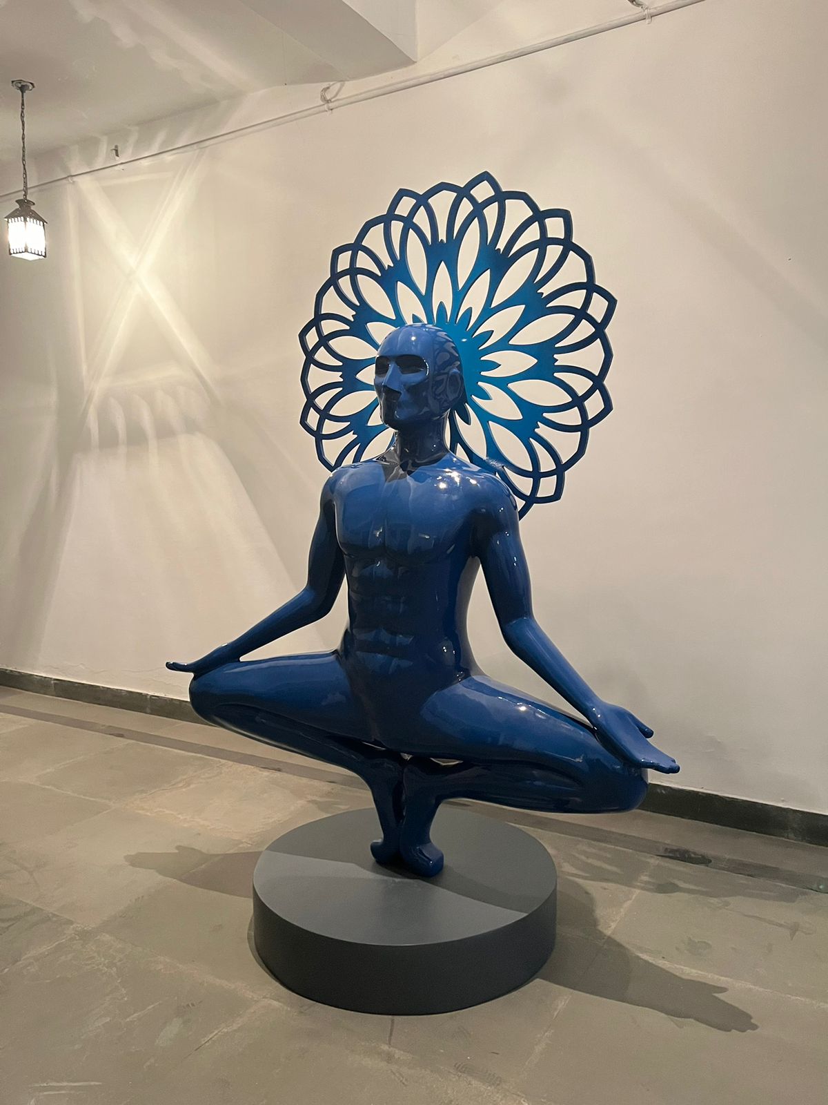 Vernika Singh 6ft blue fiberglass sculpture 'I'm the Universe' showing a meditating man balancing on his toes.