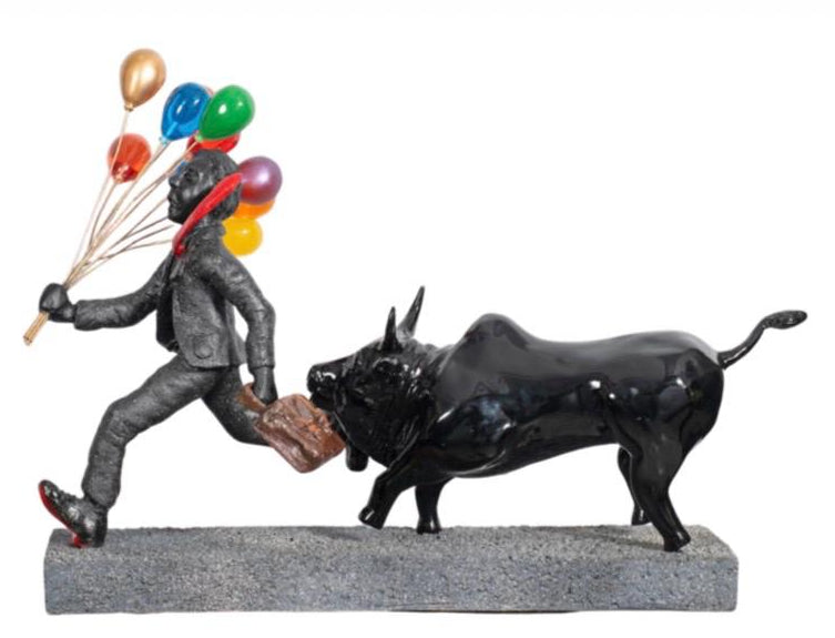 Statue of a corporate suited man striding away happily with balloons as a bull tries to grab his briefcase.