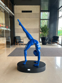 Blue Fiberglass sculpture of a person in a handstand on a black base.