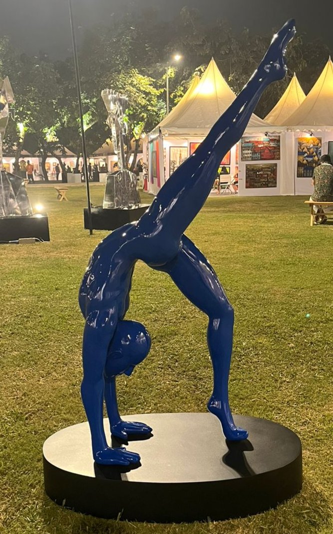 Vernika singh brings out the dynamism, flexibility and agility of human forms immersed in Yoga.  Featured her is a human form in inverted yoga. Blue fiberglass sculpture