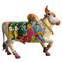 Colorful cow statue with artistic depiction on a white background of Gods in body.