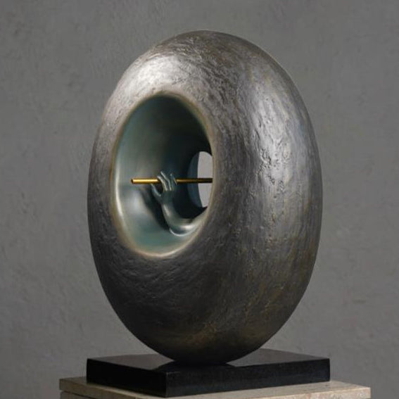 Contemporary bronze Krishna sculpture featuring embryo shaped cosmos with Krishnas flute at centre by Divyendu Anand.