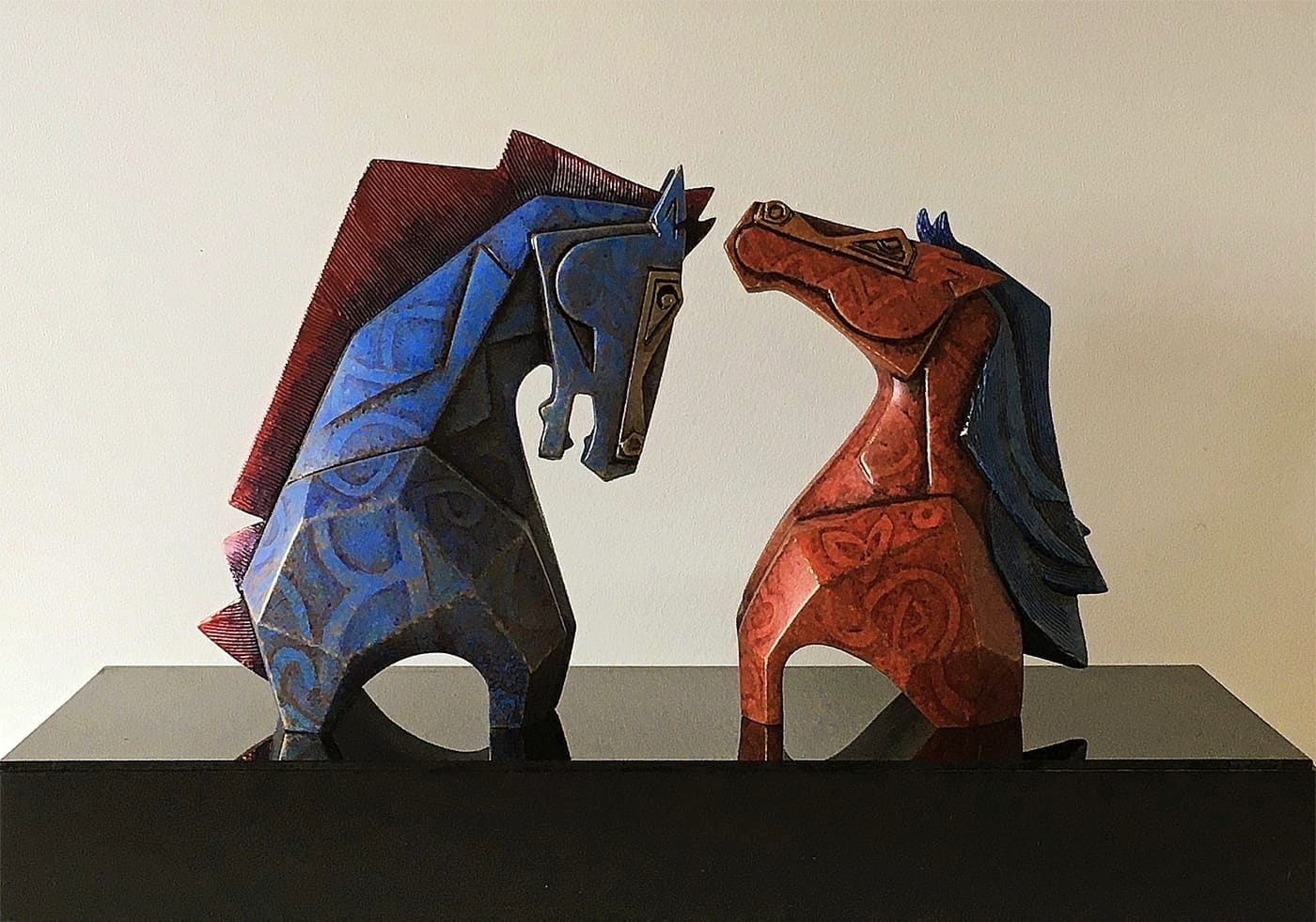 Horse Pair by Dinkar Jadhav declined in a cool blue and blazing red. The horses love for each other forms the subject even as their chiseled forms refer to their strength.