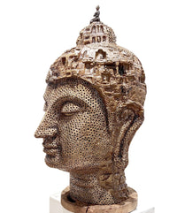 Brass sculpture of a Buddha head with intricate detailing on head.