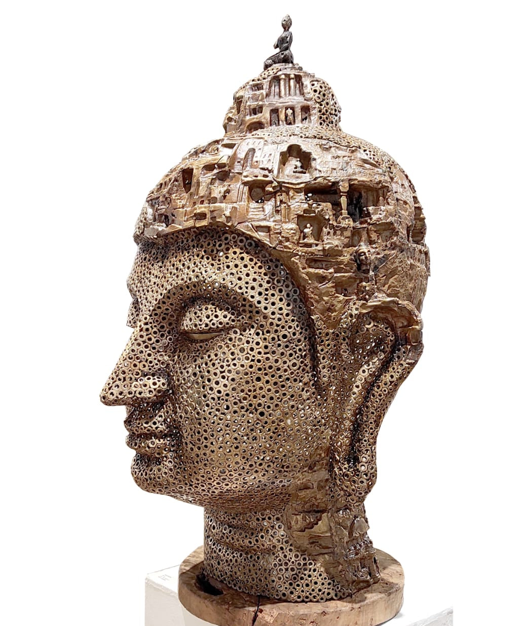 Brass sculpture of a Buddha head with intricate detailing on head.