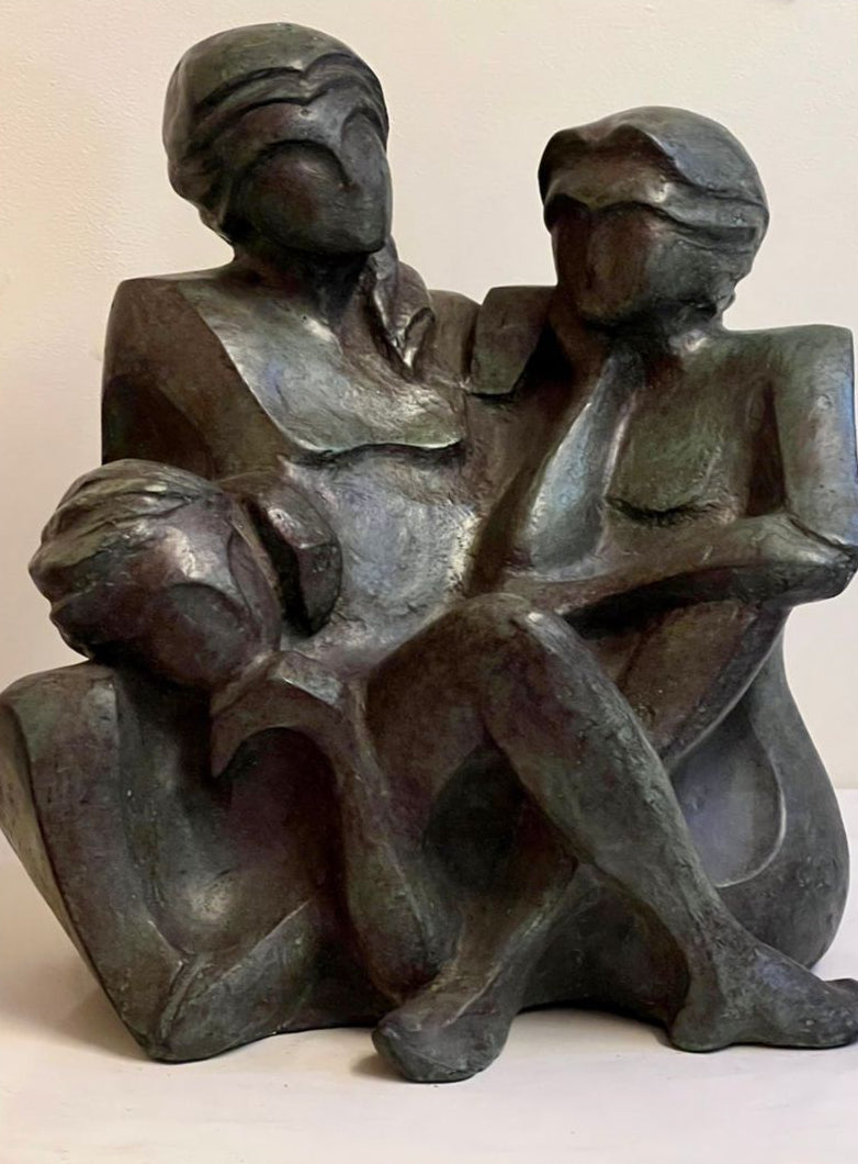 Bronze sculpture shows three seated female friends having relaxed conversation.