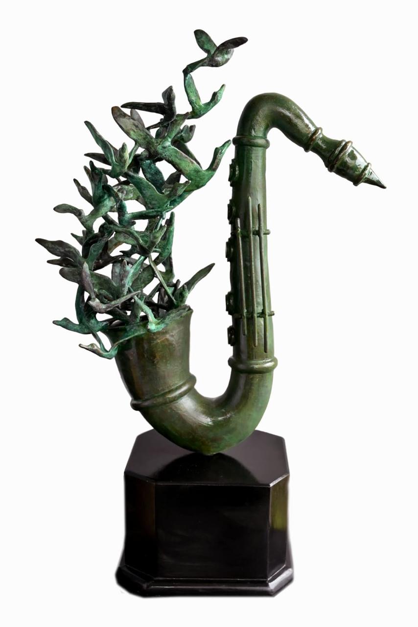 A decorative sculpture of a saxophone made with birds flying out of the mouth. 