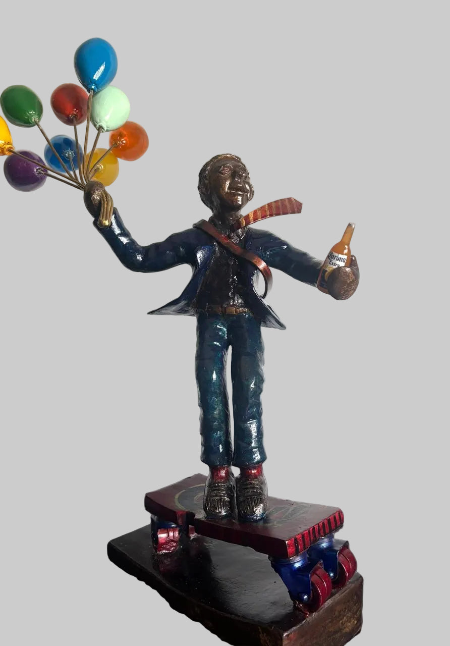 Statue of a corporate professional holding colourful balloons and beer while skating.