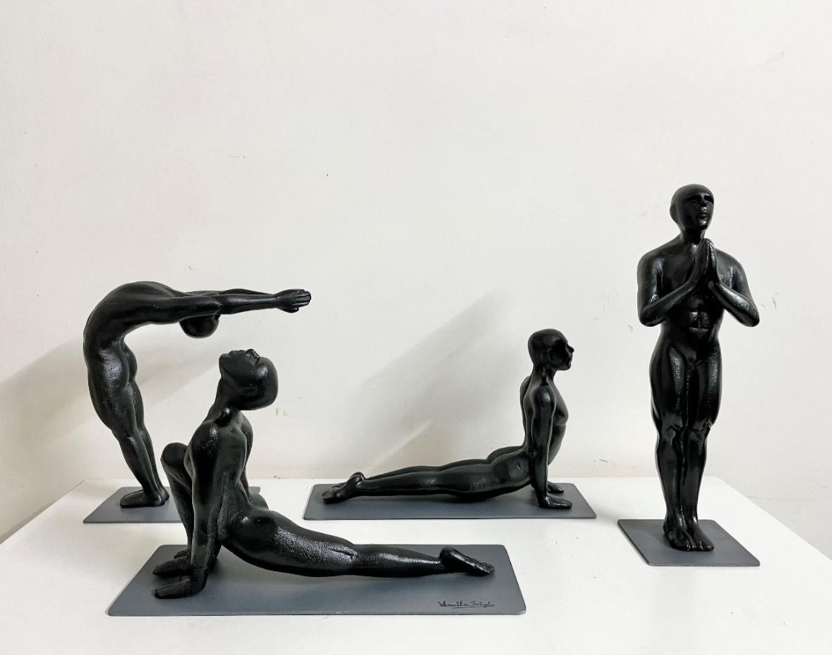 A set of three miniature aluminum yoga pose sculptures by Vernika Singh.