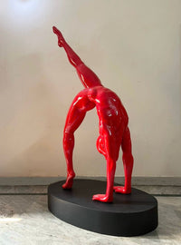 A glossy red sculpture of a human figure doing yoga by Vernika SIngh. Side Image