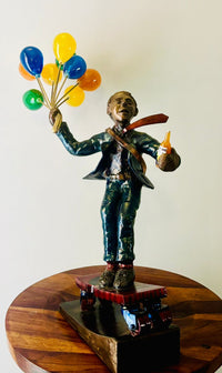 Bronze Statue of a corporate man holding balloons and beer by Tapasya Gupta.